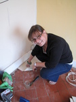 SX19976 Jenni lifting off last easy tiles of kitchen floor.jpg